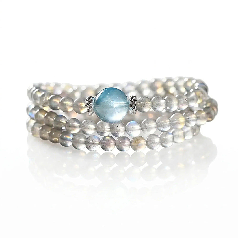 Discover the Selene Gray Moonstone & Aquamarine Wrap Bracelet at The Luxe Maison, featuring serene gemstones inspired by moonlight and ocean waves.