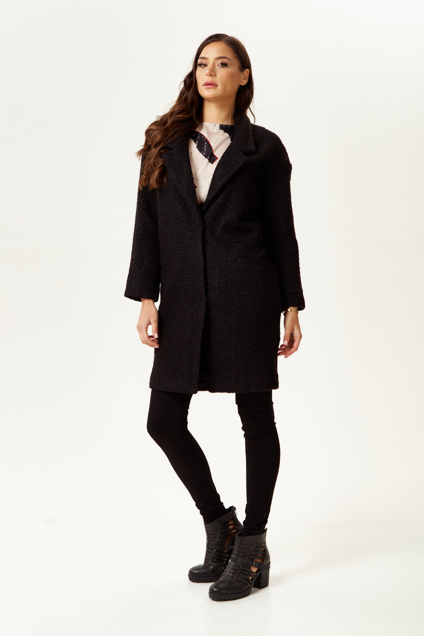 Clothing shop online offering a women’s extra loose fit black bouclé coat for chic layering. Shop Now!