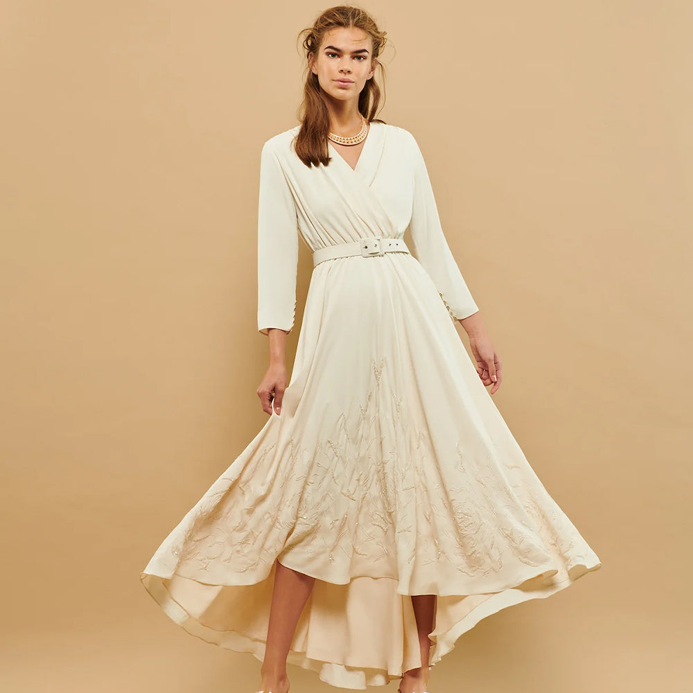 Unveil timeless elegance in this hi-lo wrap dress. Embellished with intricate embroidery and a coordinating belt.