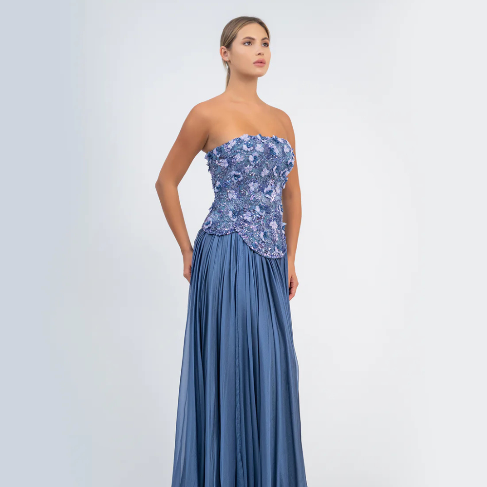 Shop online smoky blue gown with sculpted corset, floral embellishments and graceful flowing pleats, perfect for parties and special occasions.
