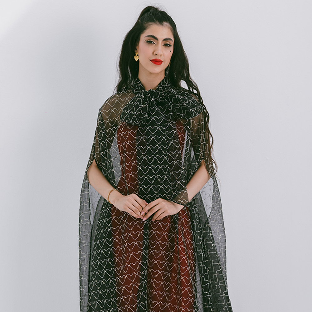 Organza cape with neck bow & heart shaped metallic threads on transparent fabric. Dress sold separately. Explore stylish capes for women. Shop now!