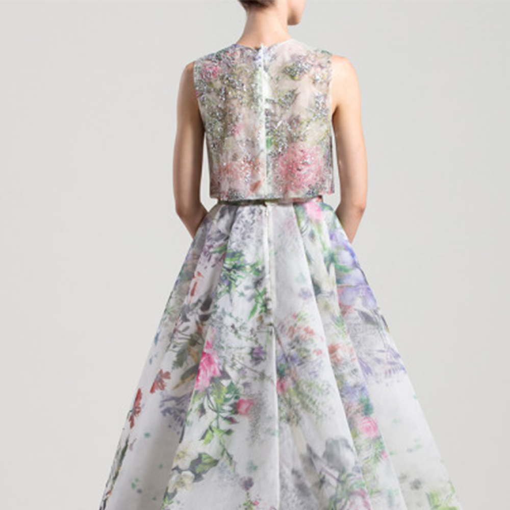 Loose, sleeveless embroidered shirt with a round neckline; high waist printed organza skirt with a slit and an overskirt.