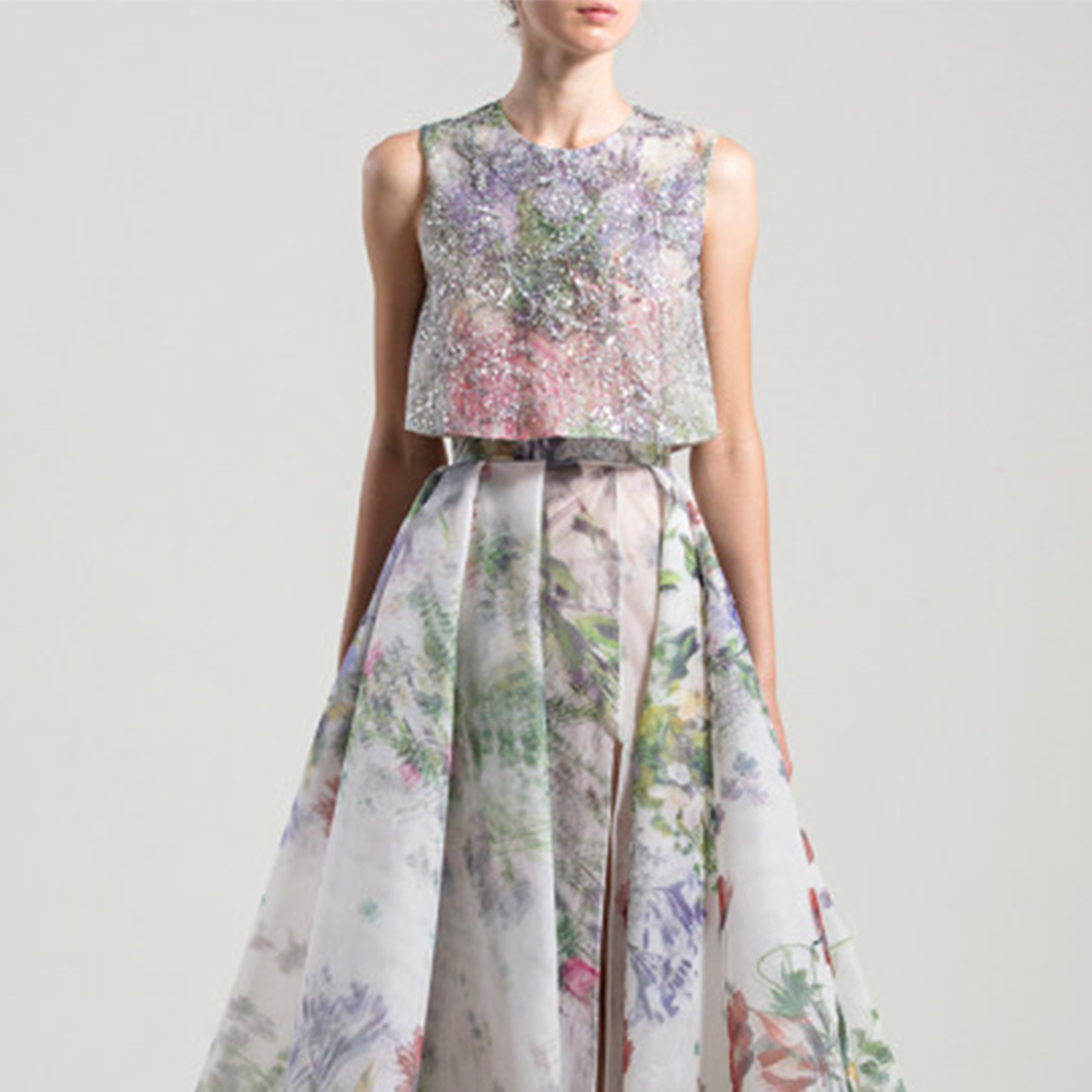Loose, sleeveless embroidered shirt with a round neckline; high waist printed organza skirt with a slit and an overskirt.