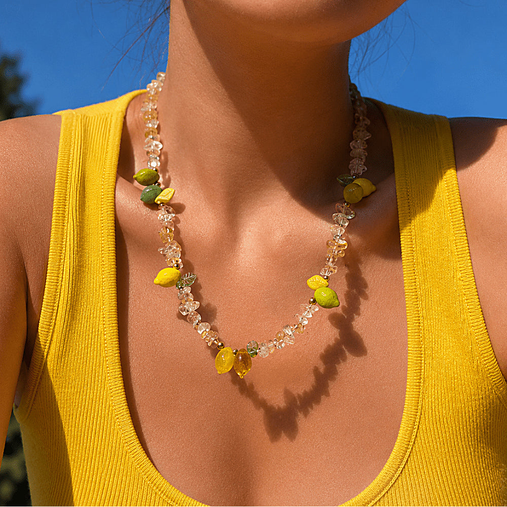 Discover the Amalfi Beaded Citrine Necklace at The Luxe Maison, featuring radiant citrine quartz and hand-carved Czech glass lemon and leaf charms for a joyful, sun-kissed summer look.