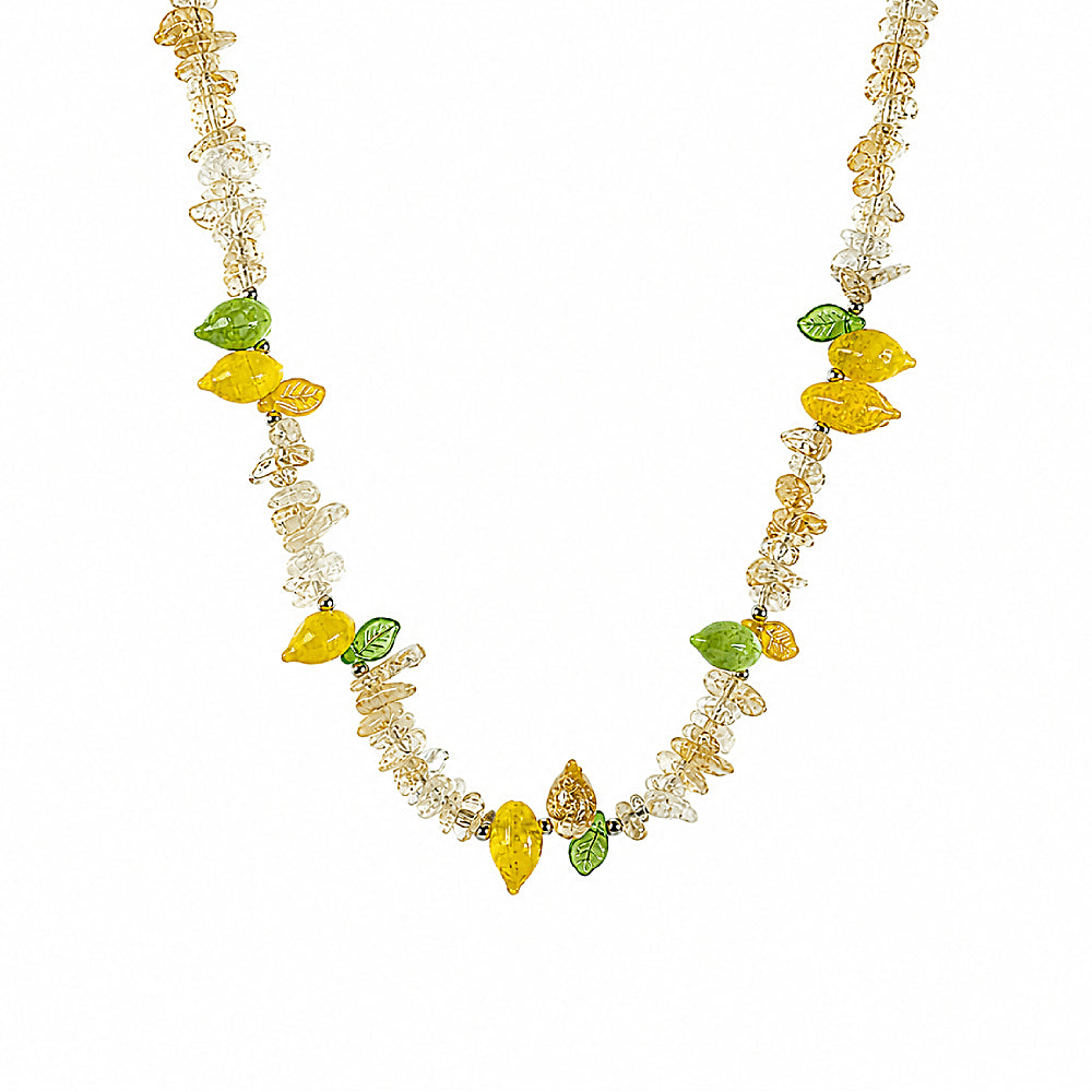 Discover the Amalfi Beaded Citrine Necklace at The Luxe Maison, featuring radiant citrine quartz and hand-carved Czech glass lemon and leaf charms for a joyful, sun-kissed summer look.