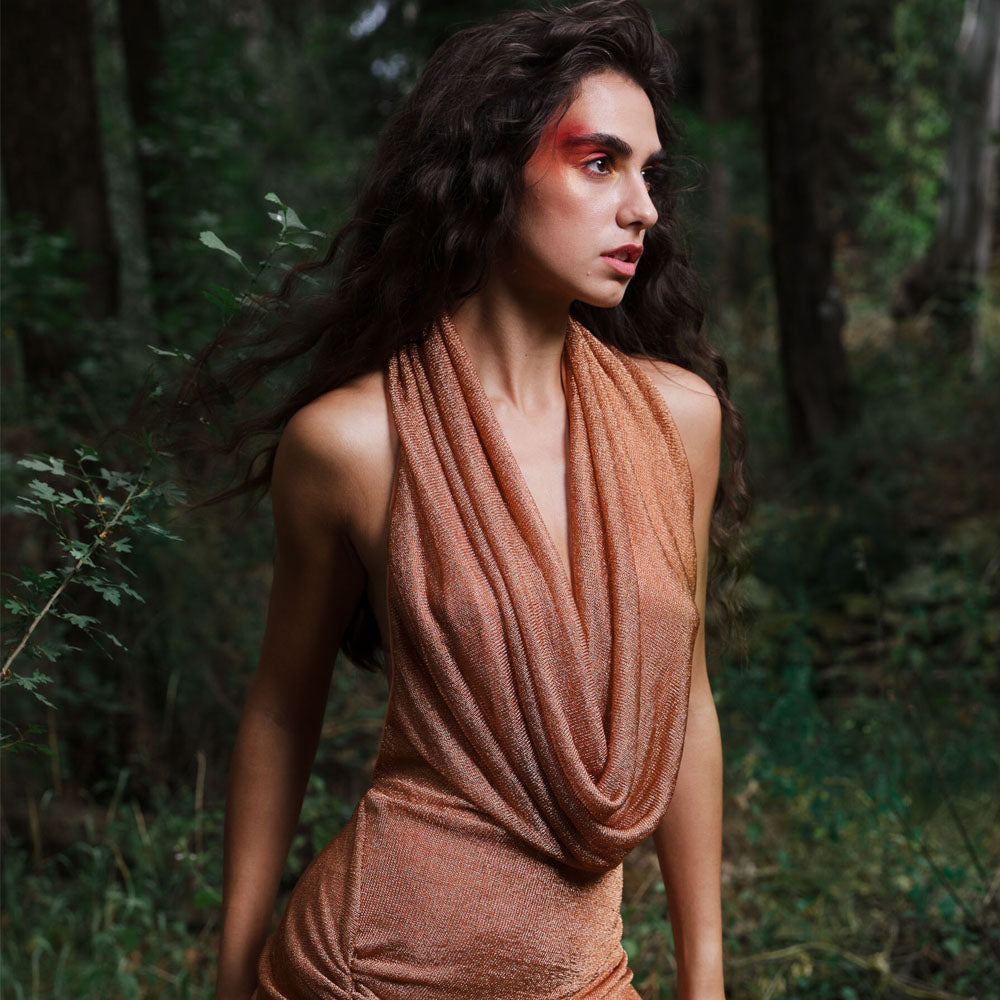 Backless, draped cowl neck dress with side gatherings in shimmer amber color mesh.