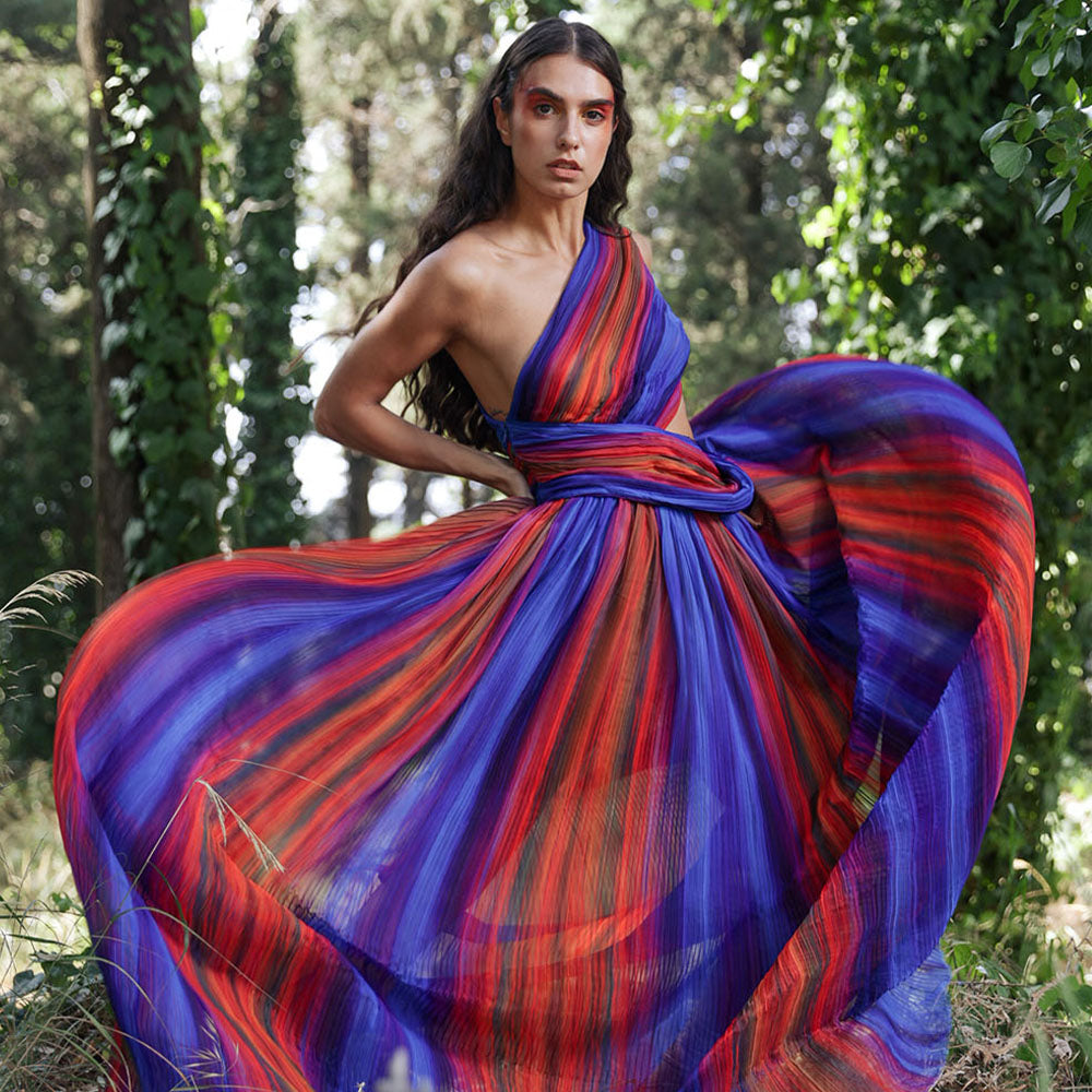 Long asymmetric pliss, dress, with cut-out detail. The exclusive printed scene on chiffon fabric.