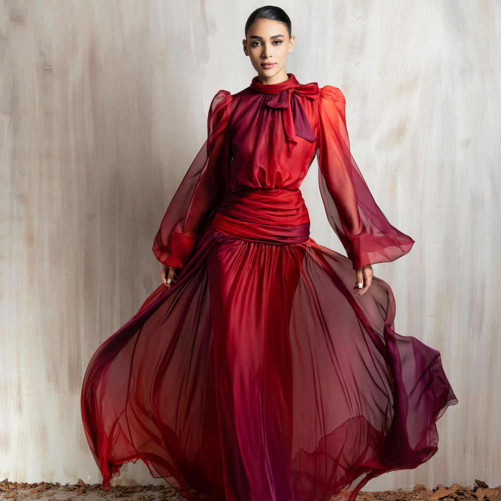 Crimson sheer gown with flowing chiffon sleeves and a cinched waist, crafted for elegant occasions. Shop now at our exclusive clothing website.