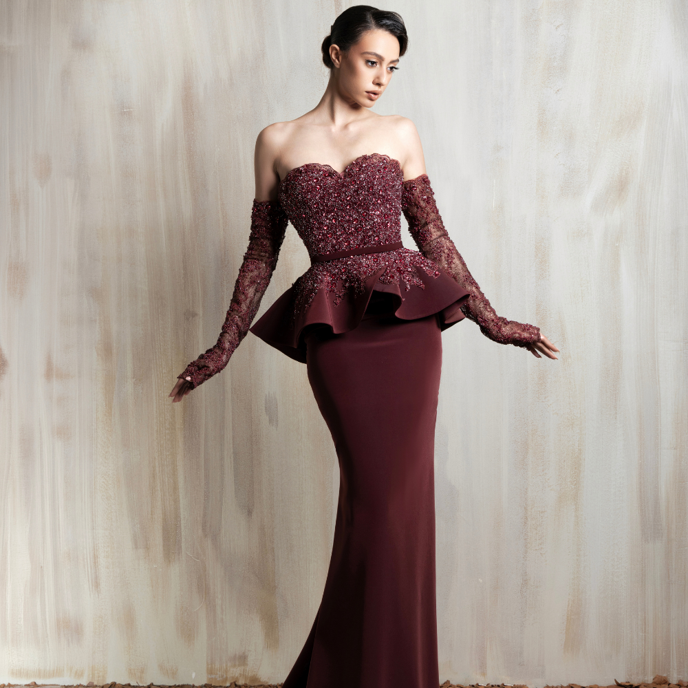 Burgundy off-shoulder gown with a beaded bodice and peplum waist, designed for elegant occasions. Shop now at our exclusive clothing website.