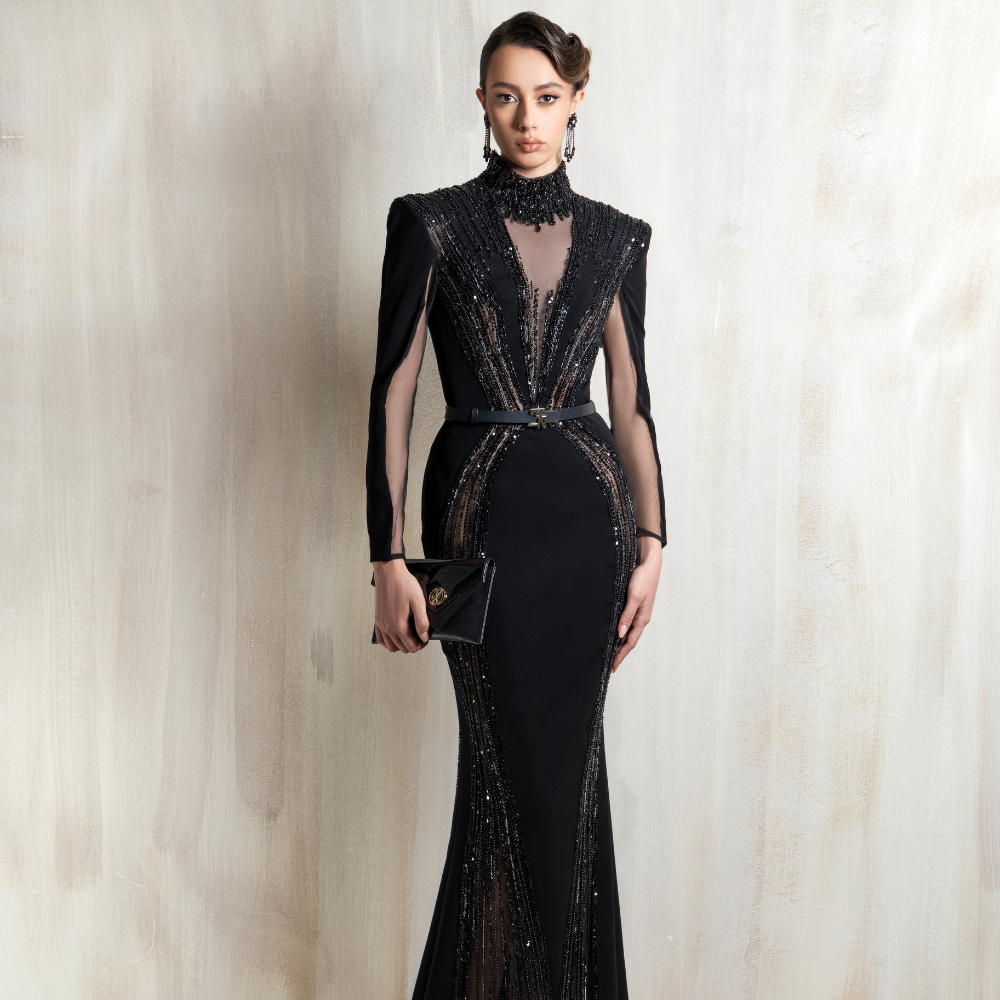 Black mermaid gown with sheer panels and embellished detailing, crafted for elegant evening wear. Shop now at our exclusive clothing website.