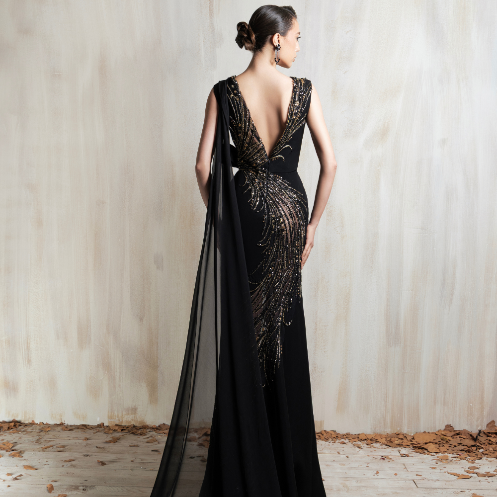 Black gown with golden cascade embroidery and a sleek flowing cape, crafted for glamorous evening events and special occasions. Shop now at our exclusive clothing website.