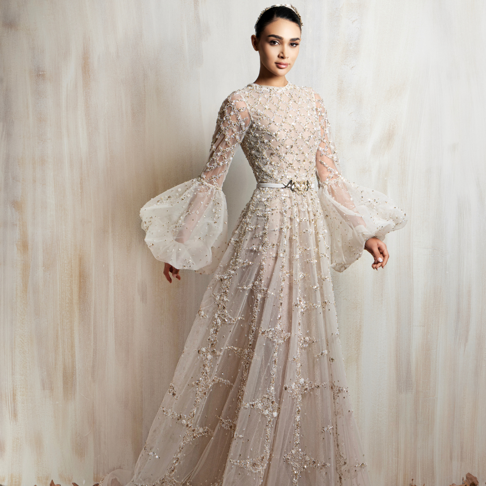 Ivory beaded long sleeve gown with sheer voluminous sleeves, designed for timeless elegance. Shop now at our exclusive clothing website.
