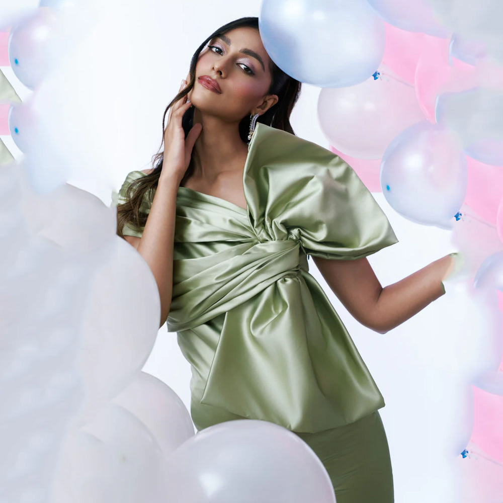Green satin maternity dress with ruched bust, bow and slit, perfect for events. Shop online from our curated edit of premium fashion.