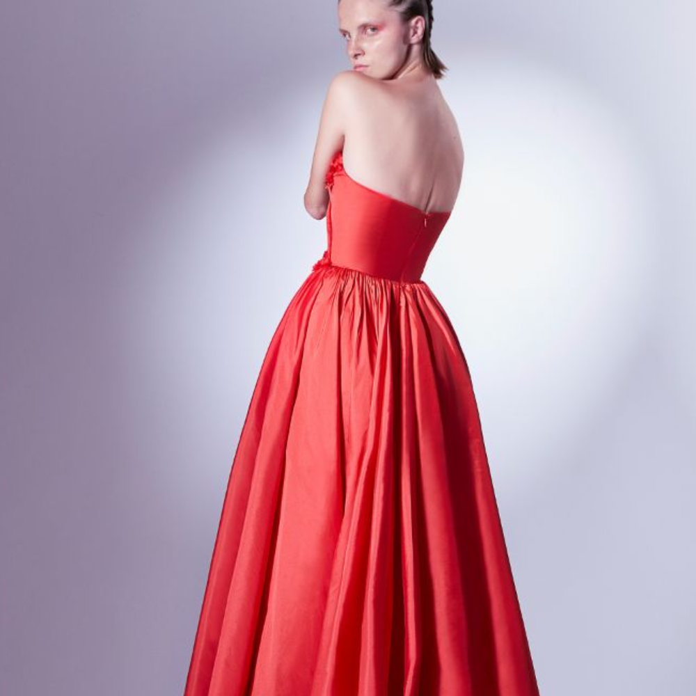 Crafted in red taffeta, this ball gown dress gently pleats on the bodice, and is adorned with three-dimensional flower details.