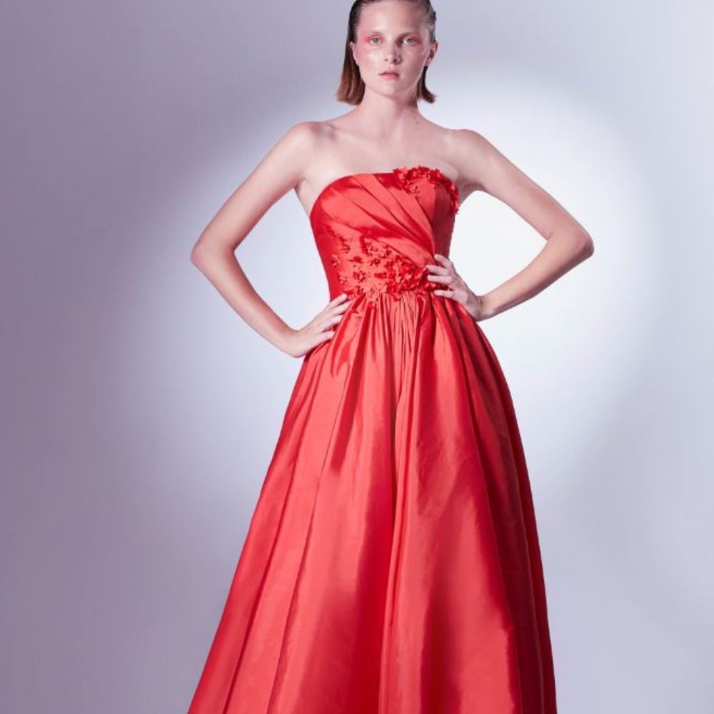 Crafted in red taffeta, this ball gown dress gently pleats on the bodice, and is adorned with three-dimensional flower details.