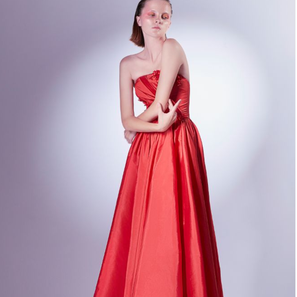 Crafted in red taffeta, this ball gown dress gently pleats on the bodice, and is adorned with three-dimensional flower details.