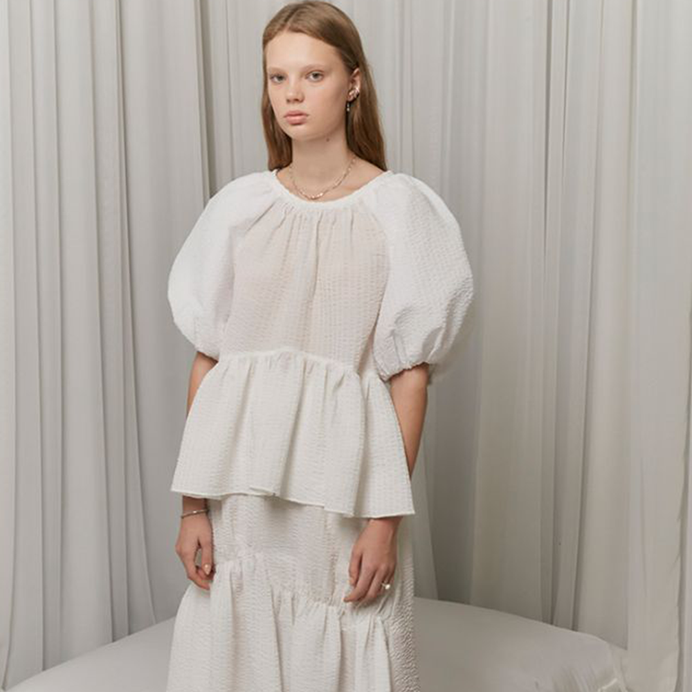 Raw-edged, Round neckline One side handkerchief-hem with patch pocket Adjustable tie belt at waist Relaxed silhouette.