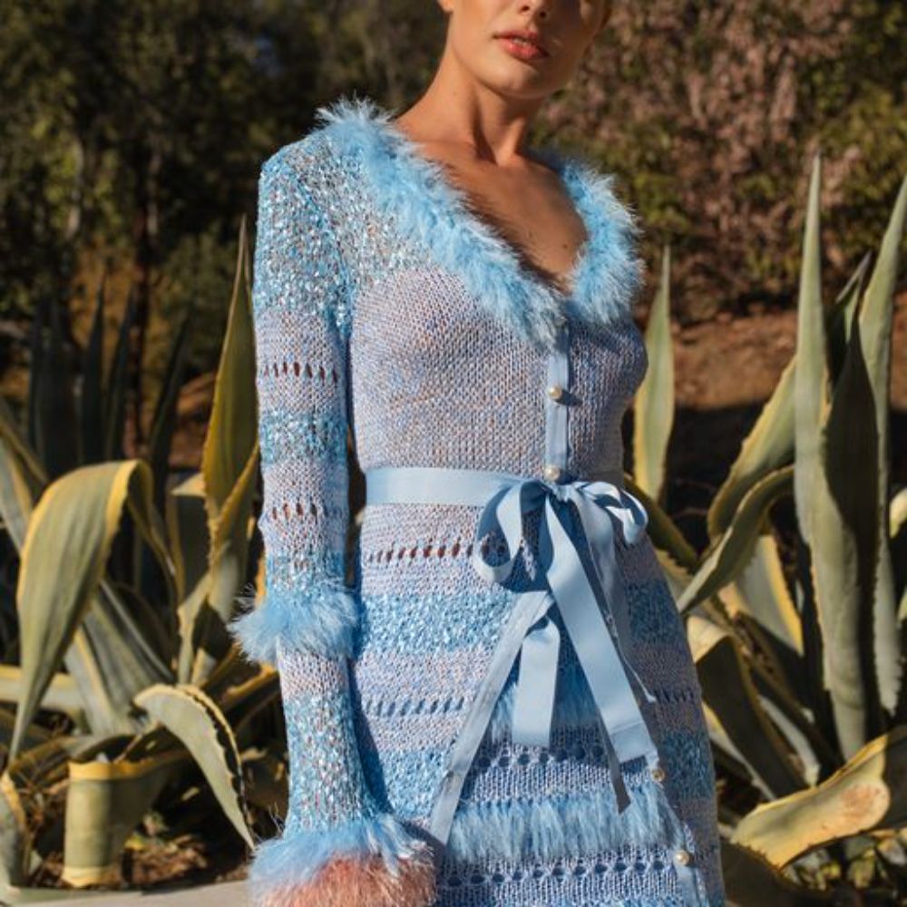 The Blue handmade sweater with long sleeves has wavy knit ruffles and looks like a piece of art. 