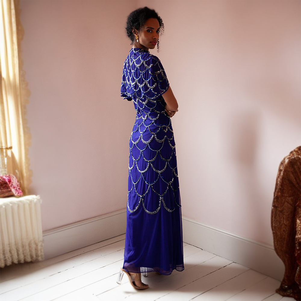 This glamorous blue floor-length gown features gold and silver sequins as well as a cape that can be taken on or off