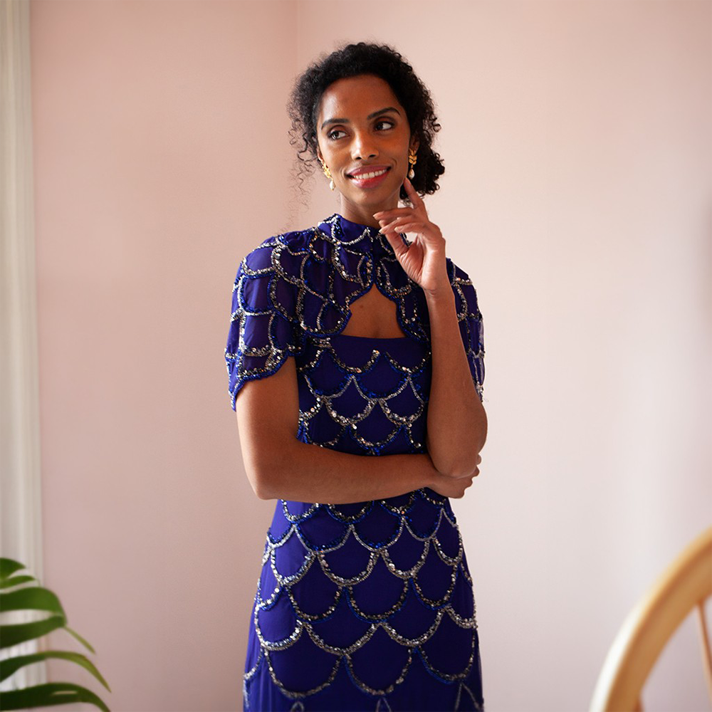 This glamorous blue floor-length gown features gold and silver sequins as well as a cape that can be taken on or off