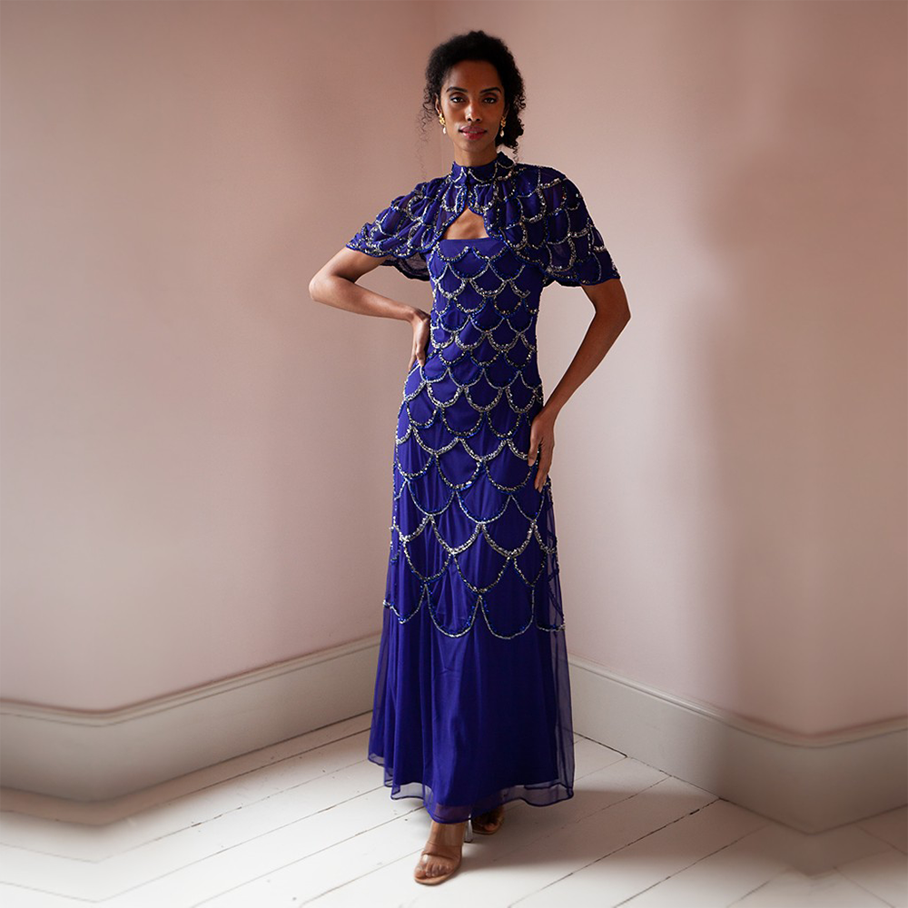 This glamorous blue floor-length gown features gold and silver sequins as well as a cape that can be taken on or off