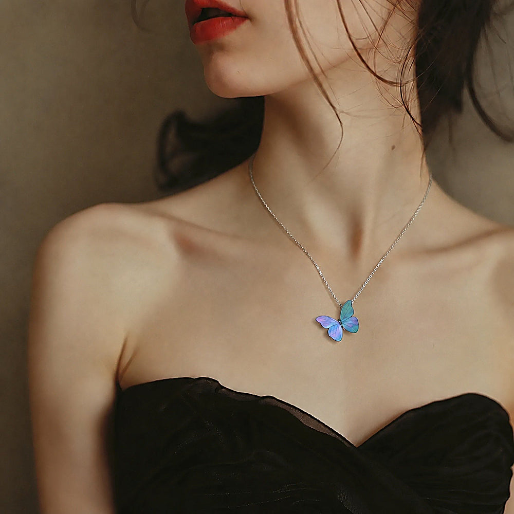 Discover the Blue Morpho Butterfly Necklace at The Luxe Maison, featuring iridescent mother-of-pearl inlay, traditional lacquer artistry, and a silver setting.