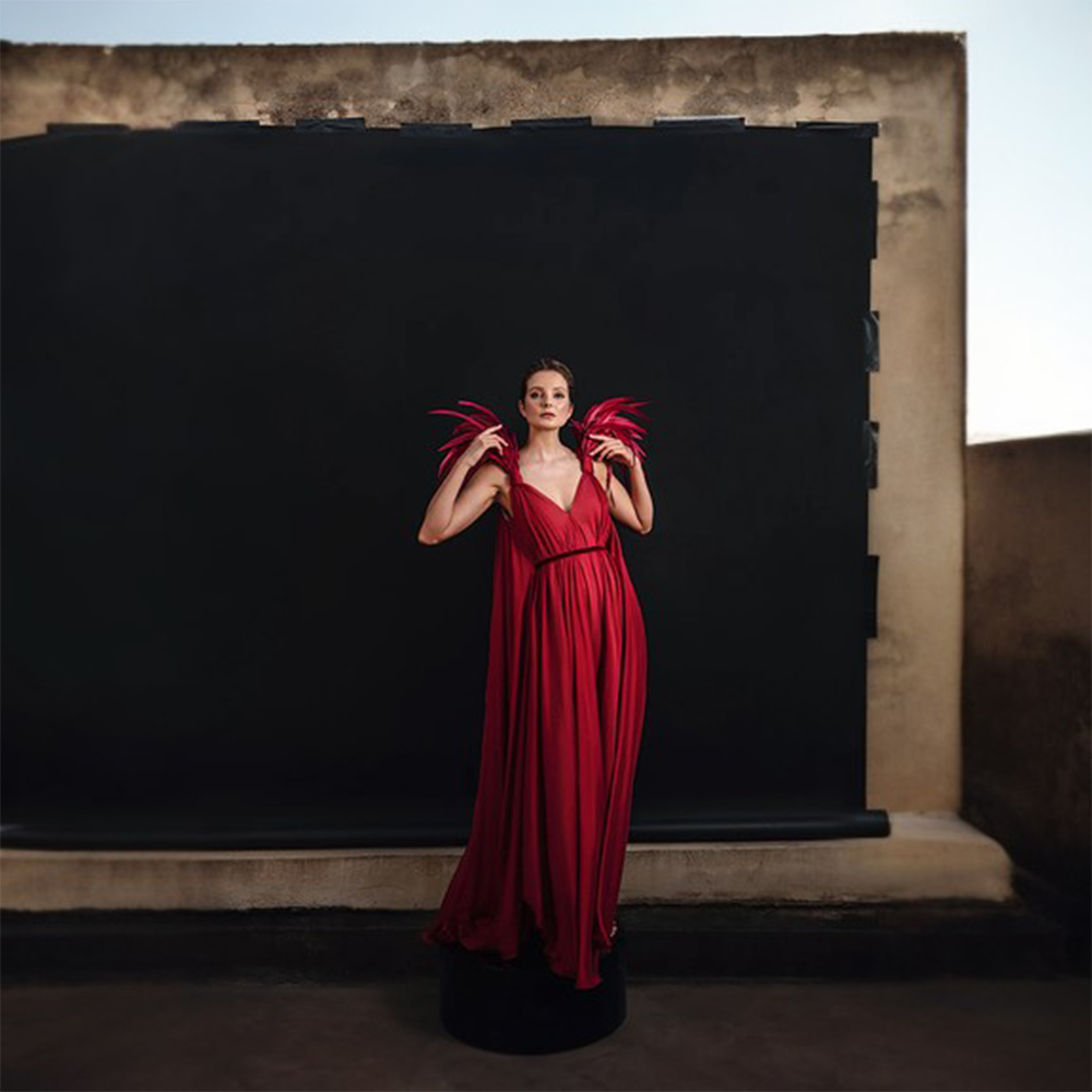 A deep saturated burgundy silk chiffon dress with a plunging neckline and feathered shoulders.