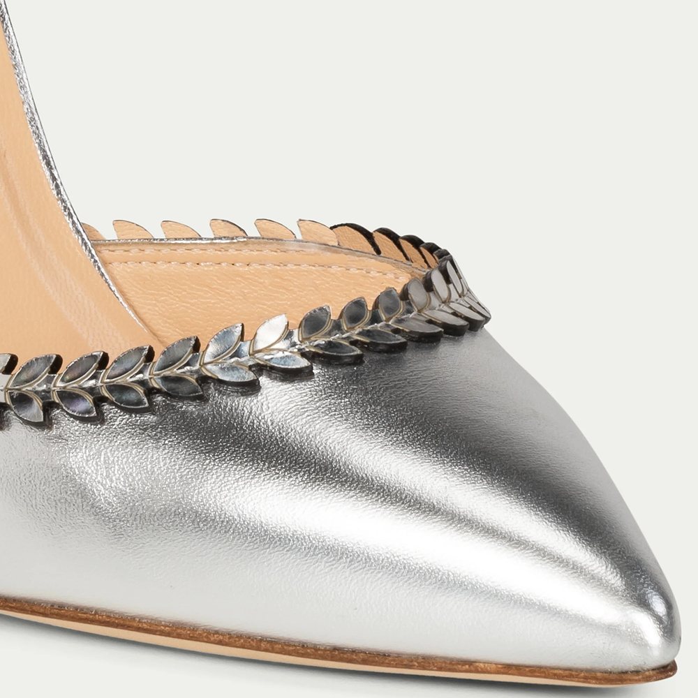 This silver shiny leather pump with laser foliage strap is hand-finished in Italy. Pointed toe. 