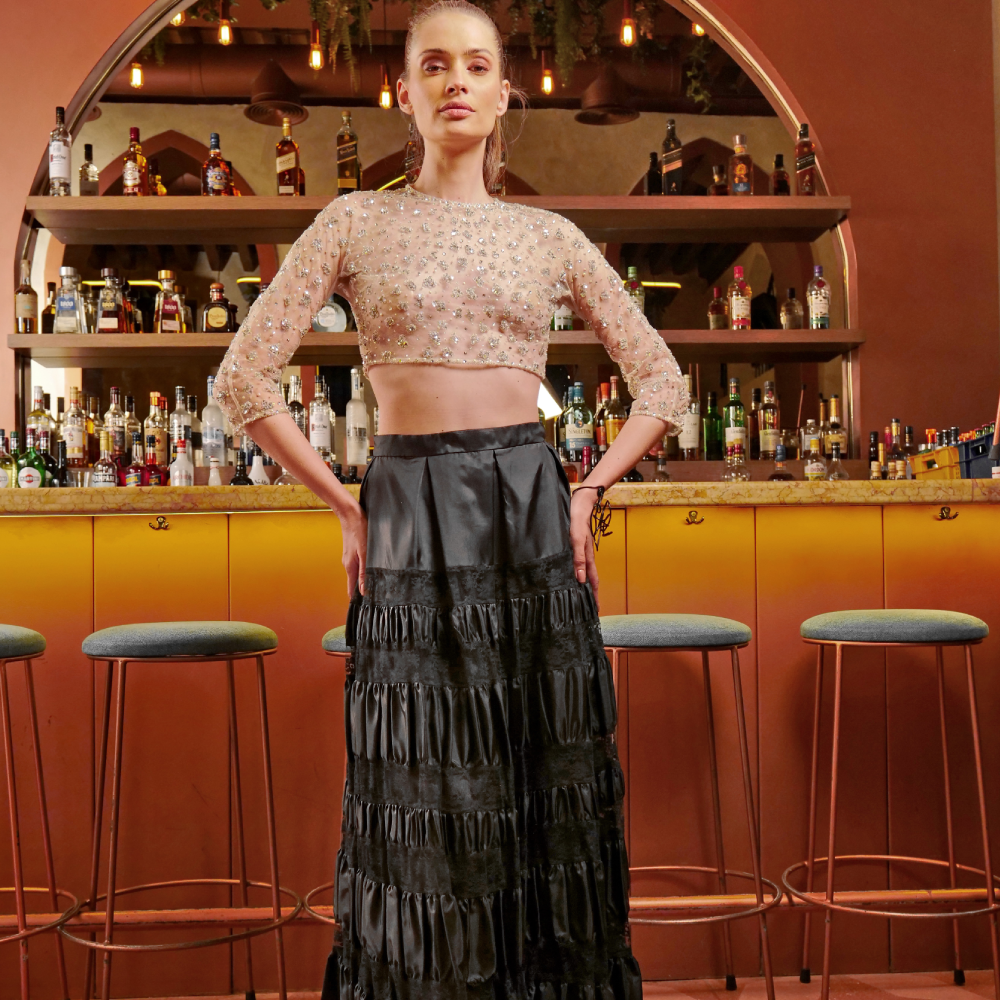 Dazzle in this ensemble: a black taffeta skirt with draped elegance paired with a tulle crop top adorned in silver sequins.