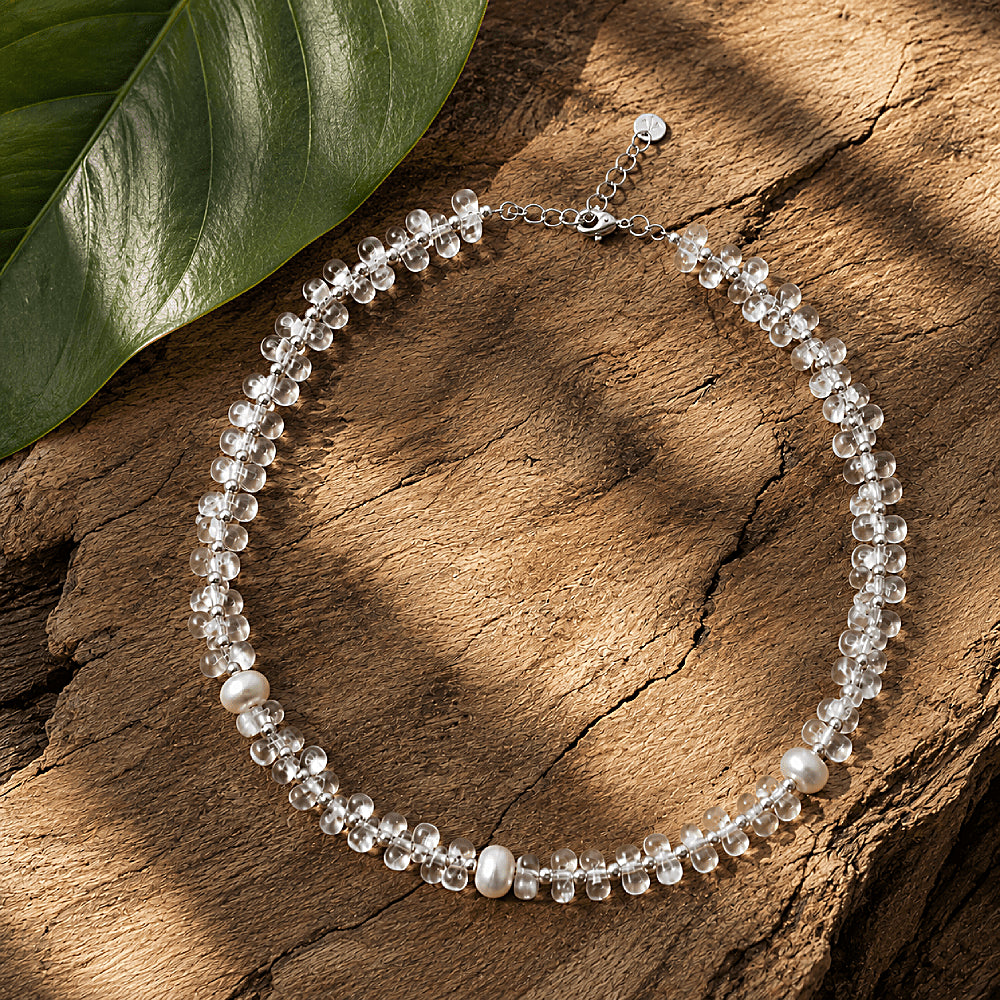 Discover the Elara Clear Quartz Beaded Necklace at The Luxe Maison, featuring luminous clear quartz beads and brushed silver-tone accents for an elegant, minimalist look inspired by the beauty of nature.