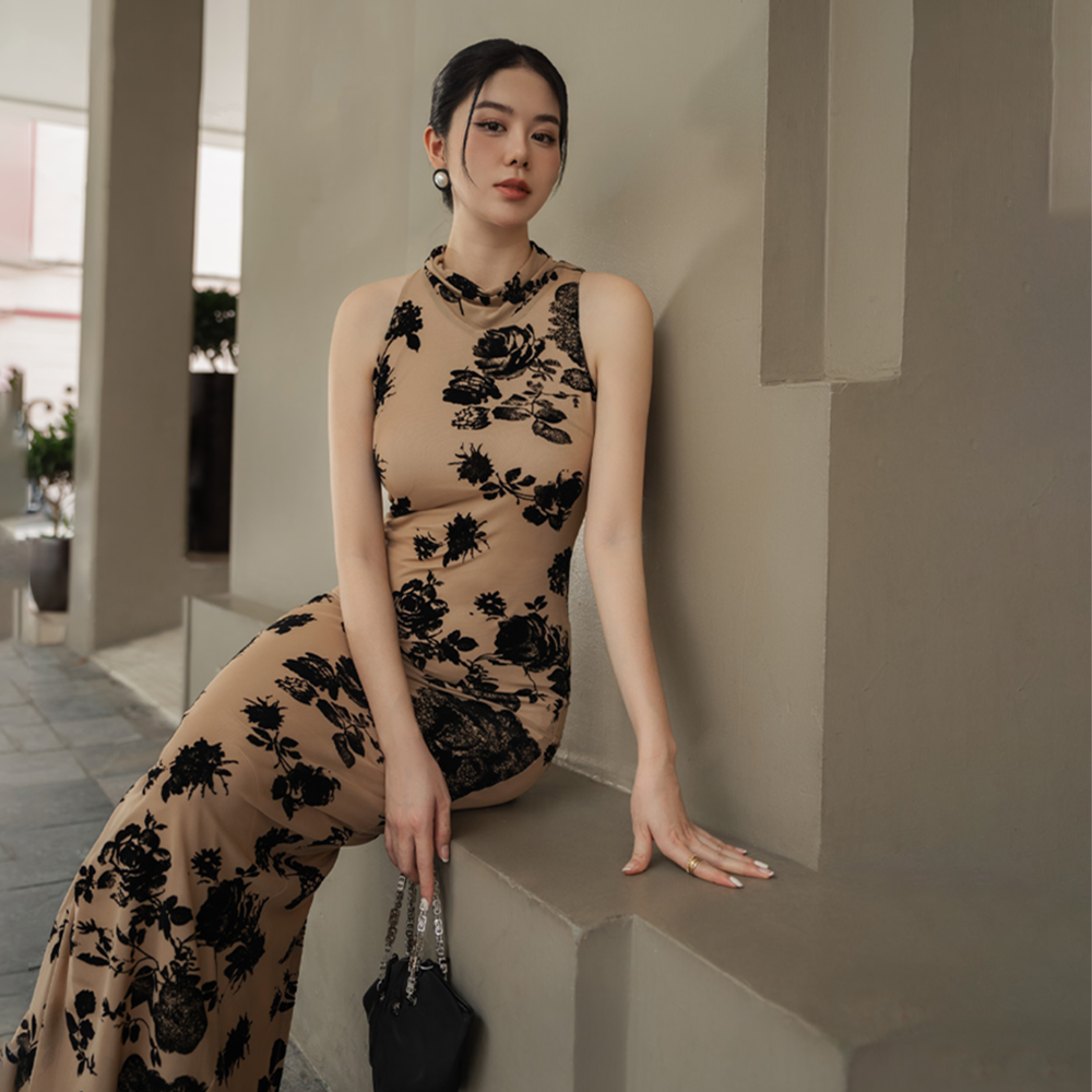 Striking in its simplicity, this nude brown dress with rose print dress is cut with a halterneck and a floor-grazing hemline.