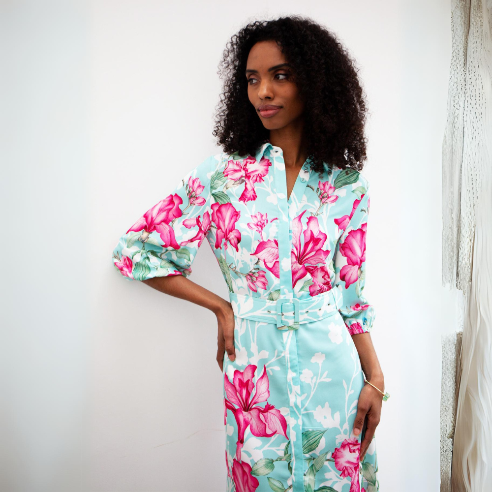 This sophisticated shirt midi dress features a bold pink floral pattern with a turquoise and white background