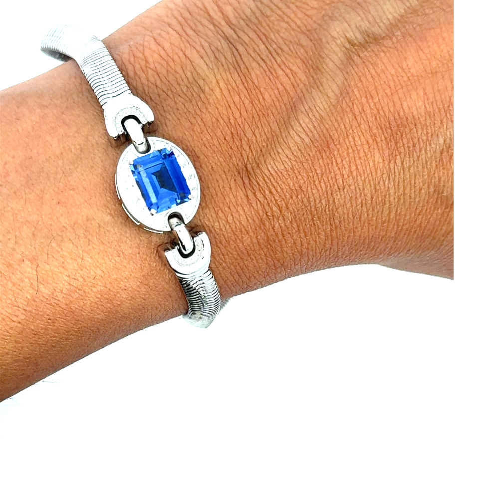 Sterling silver bracelet featuring a square emerald-cut lab-created blue sapphire center stone framed with sparkling cubic zirconia accents. Shop premium jewelry online.