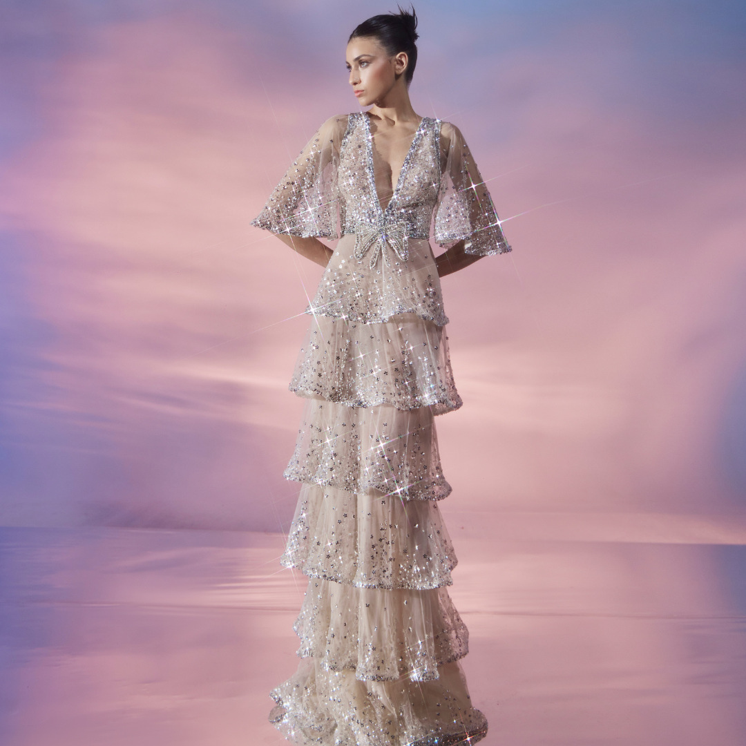 Plunging neckline flutter sleeve Nude tulle dress, layered skirt adorned with shimmering Silver embellishments.
