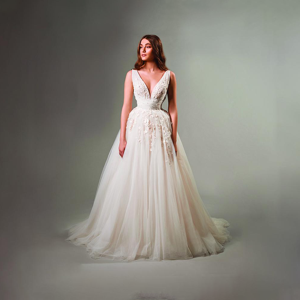 Gathered embroidered gown with soft creations embellished with floral motives and sinuous natural lines.