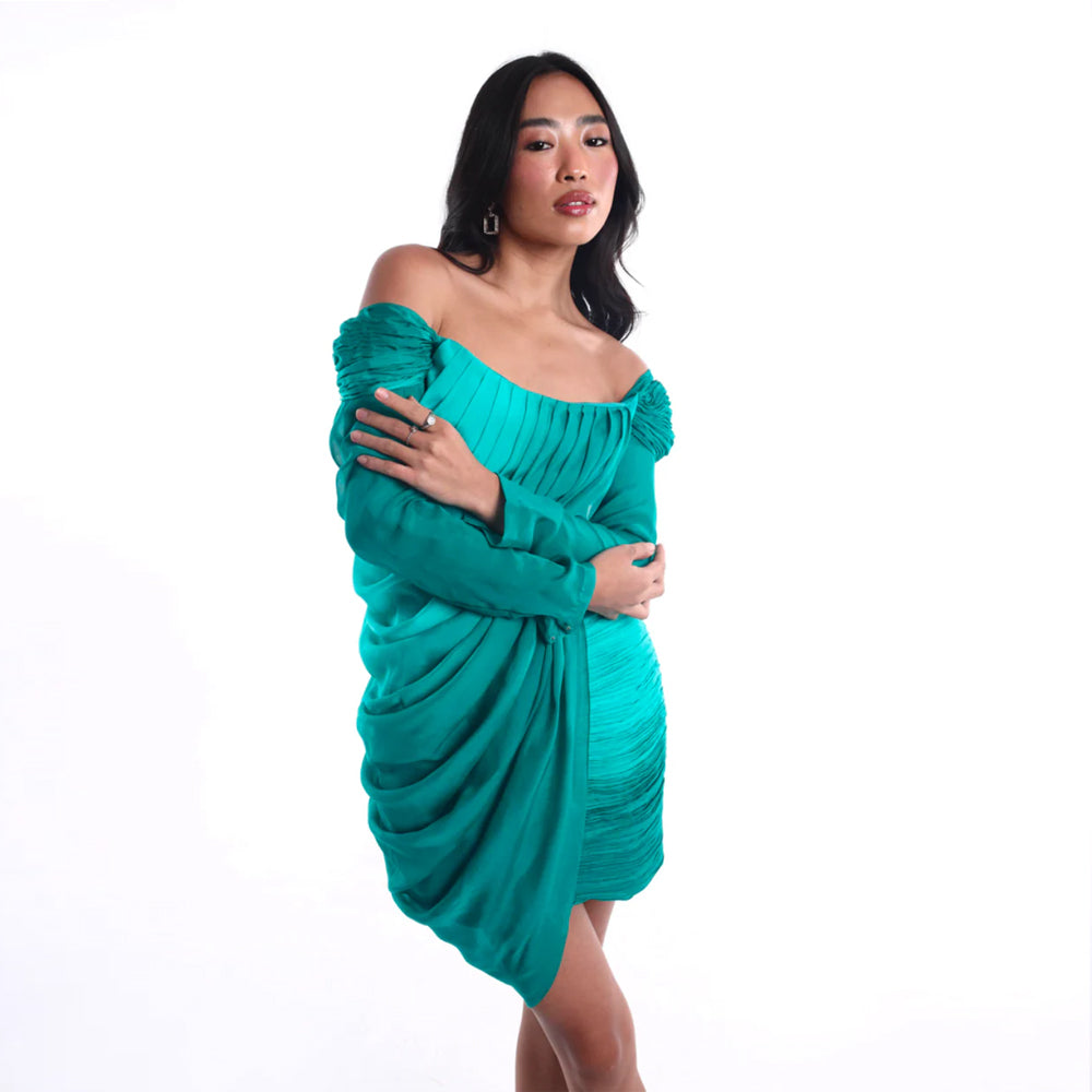 Emerald off shoulder mini dress with pleated bodice and ruched skirt, perfect for parties. Shop online from our curated edit of premium fashion.