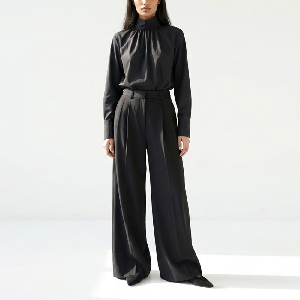 Discover the Ila Blouse at The Luxe Maison, featuring a wide-cut silhouette, stand-up collar, concealed back fastenings, and an asymmetric waistband for versatile styling.