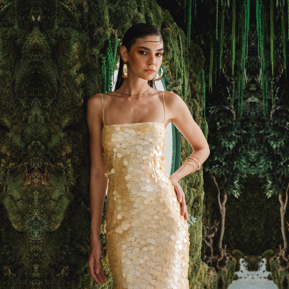Shop online from our exclusive website and discover the Karya Dress by Nana Gotti, a gold sequin slip dress with delicate lace, slim straps, and an elegant floor-length silhouette.
