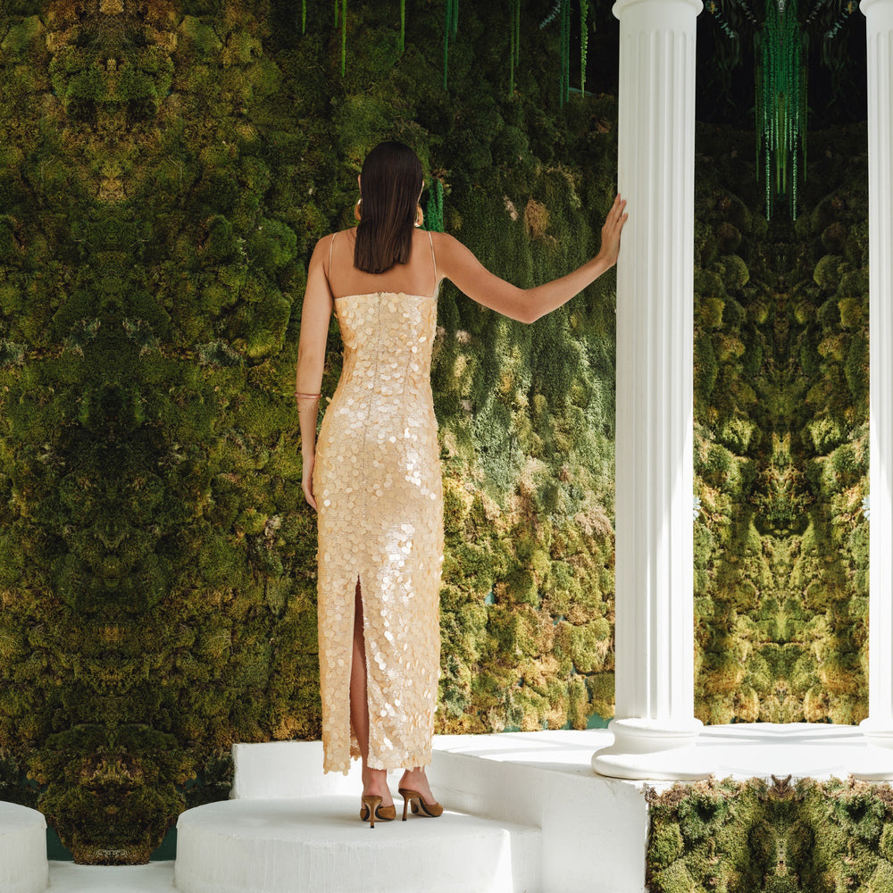 Shop online from our exclusive website and discover the Karya Dress by Nana Gotti, a gold sequin slip dress with delicate lace, slim straps, and an elegant floor-length silhouette.