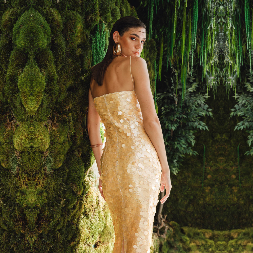 Shop online from our exclusive website and discover the Karya Dress by Nana Gotti, a gold sequin slip dress with delicate lace, slim straps, and an elegant floor-length silhouette.