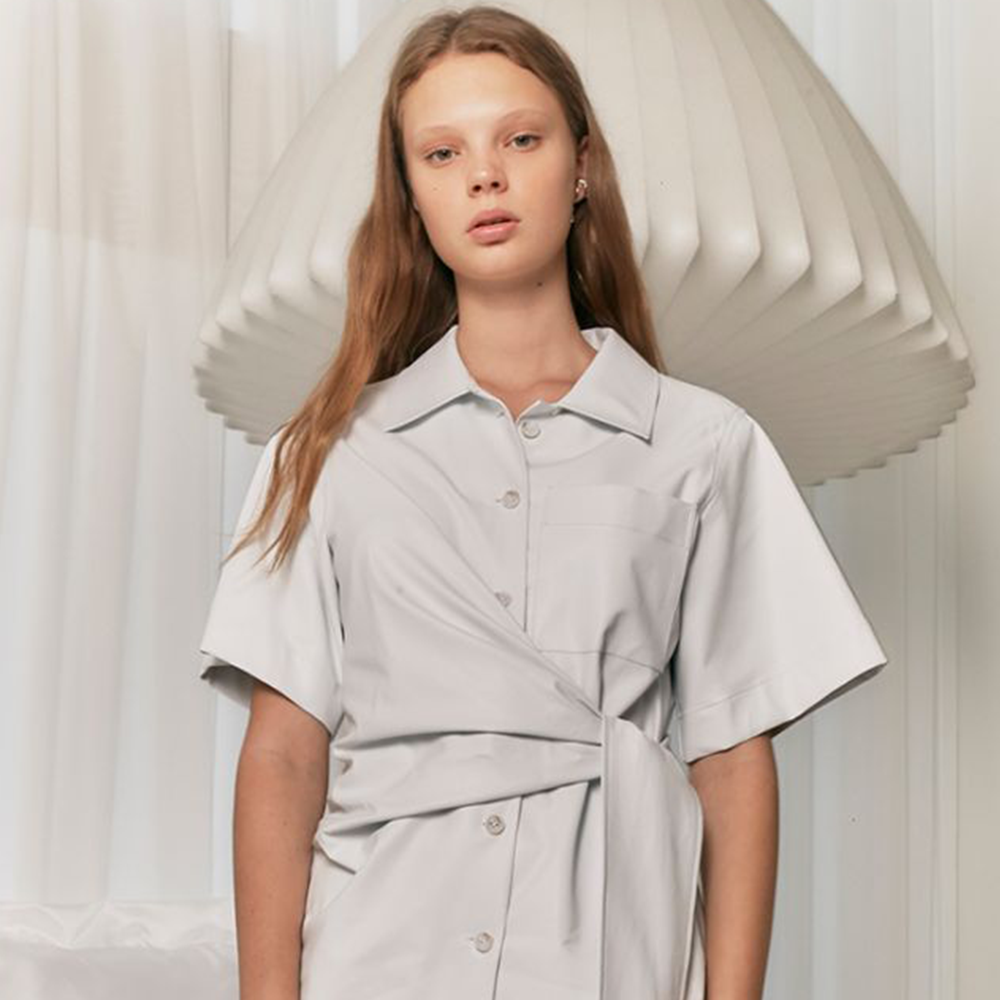Raw-edged, Round neckline One side handkerchief-hem with patch pocket Adjustable tie belt at waist Relaxed silhouette.