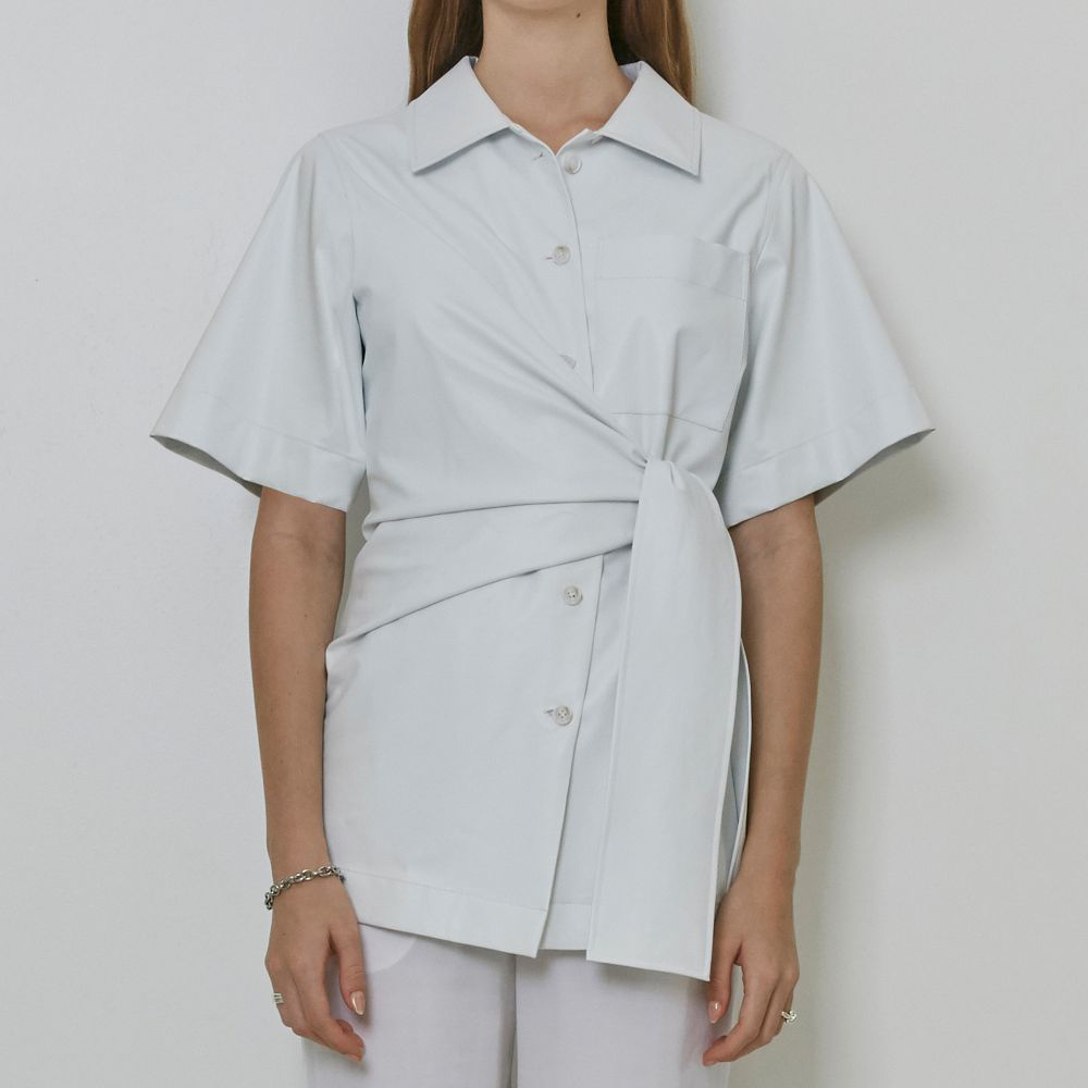 Raw-edged, Round neckline One side handkerchief-hem with patch pocket Adjustable tie belt at waist Relaxed silhouette.