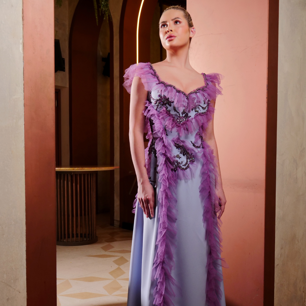 Elegant long crepe dress in light blue, adorned with intricate purple embroidery and delicate tulle ruffles
