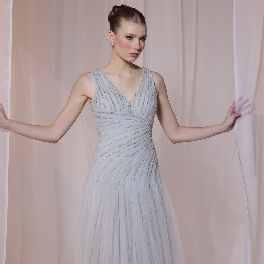 Shop online soft grey gown with delicate V-neckline, subtle shimmer and airy flowing silhouette, perfect for parties and special occasions.