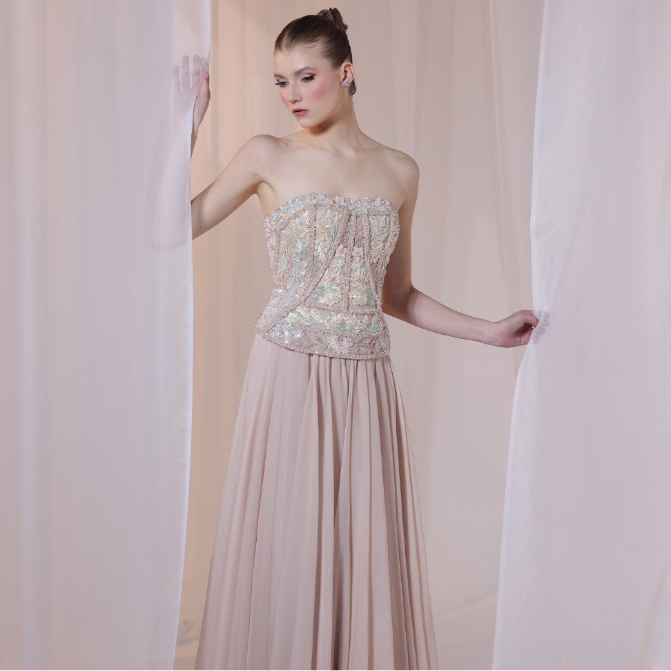 Shop online soft nude gown with embellished corset bodice and flowing pleated silhouette, perfect for parties, receptions and special occasions.
