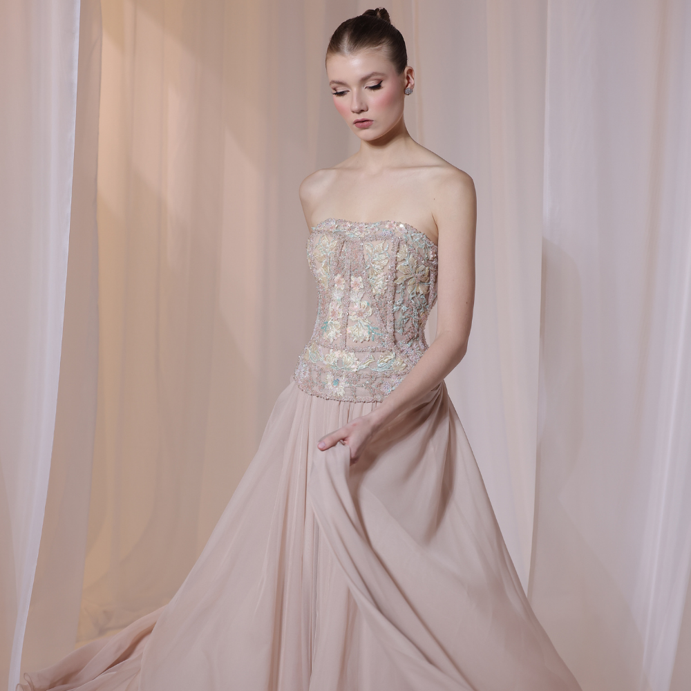 Shop online soft nude gown with embellished corset bodice and flowing pleated silhouette, perfect for parties, receptions and special occasions.