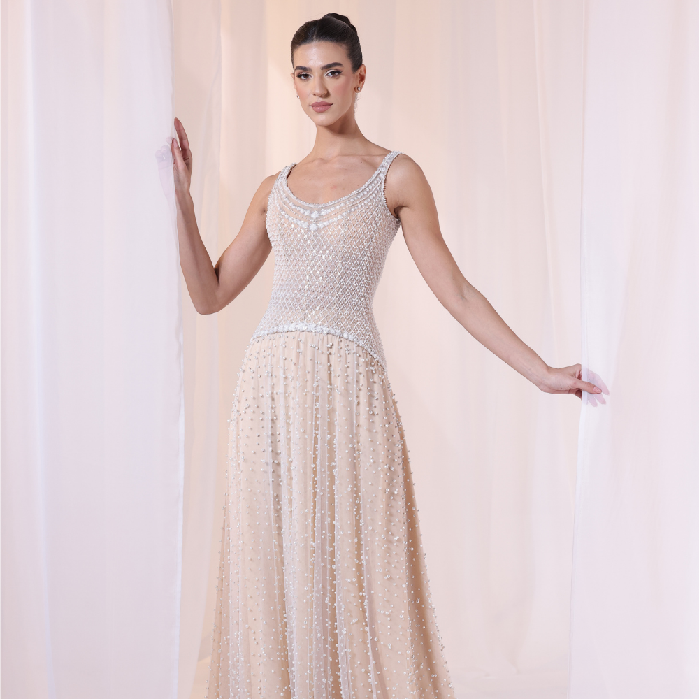 Shop online nude-toned gown with intricate beadwork, delicate textures and flowing embellished layers, perfect for parties and special occasions.