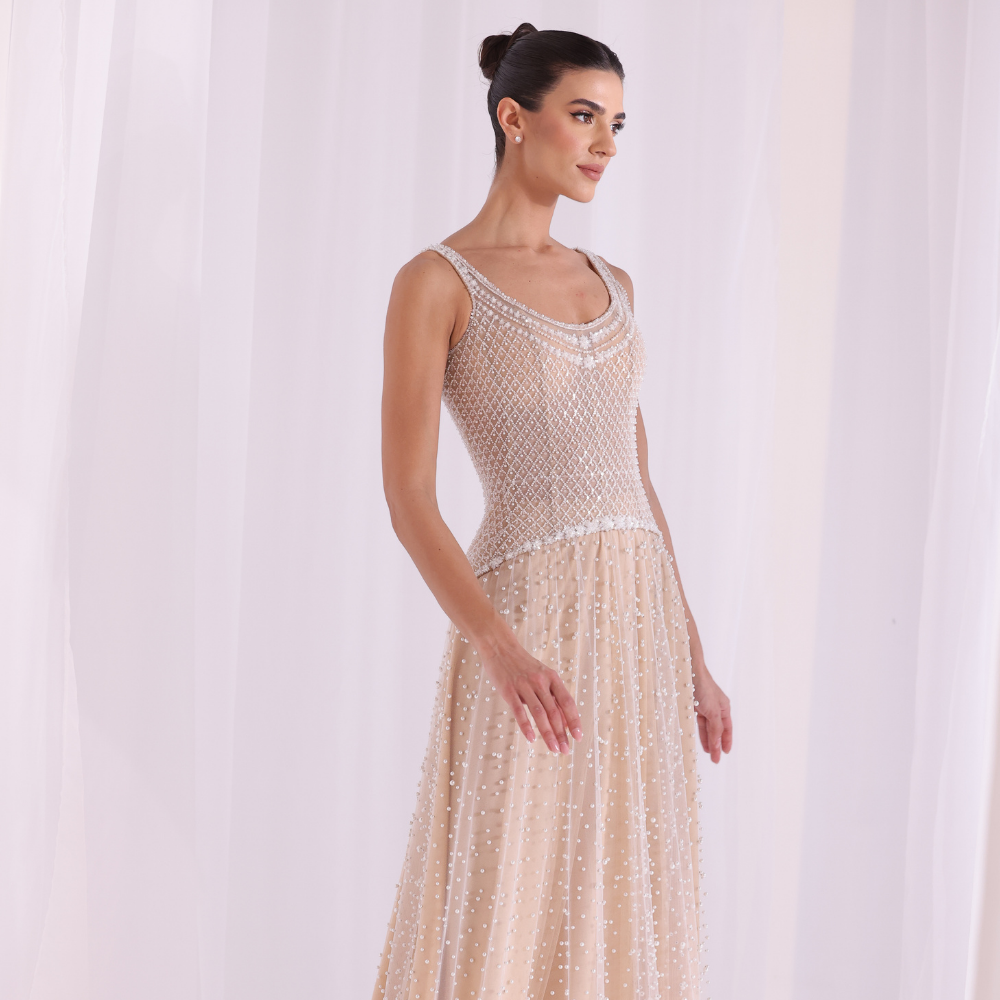 Shop online nude-toned gown with intricate beadwork, delicate textures and flowing embellished layers, perfect for parties and special occasions.