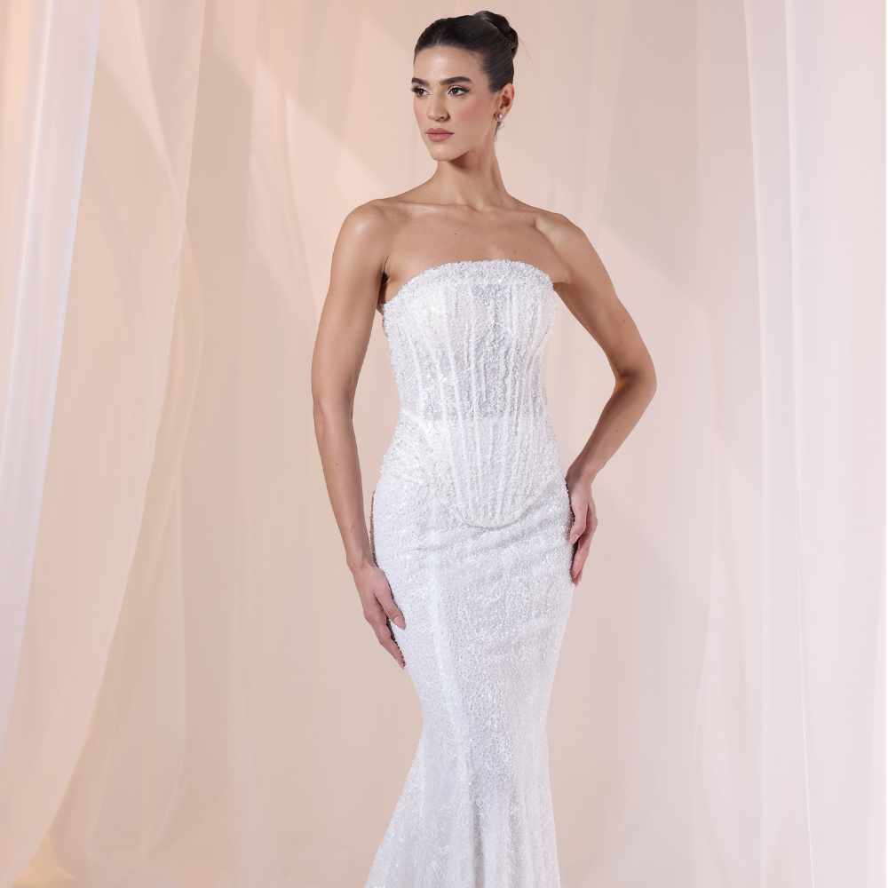 Shop online soft ivory gown with delicate shimmer, structured corset bodice and elegant fitted silhouette, perfect for parties and special occasions.