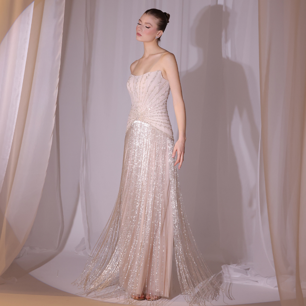 Shop online blush embellished gown with delicate detailing and fluid shimmering layers, inspired by Charleston elegance and perfect for special occasions.